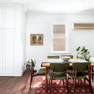 a dining room with a table and chairs and a painting on the wall