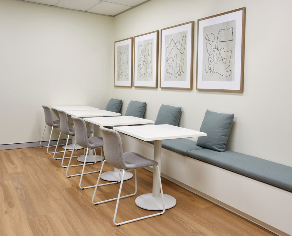a row of tables and chairs in a room with drawings on the wall