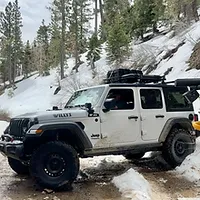 White Wrangler Ecodiesel on snowy mountain road.