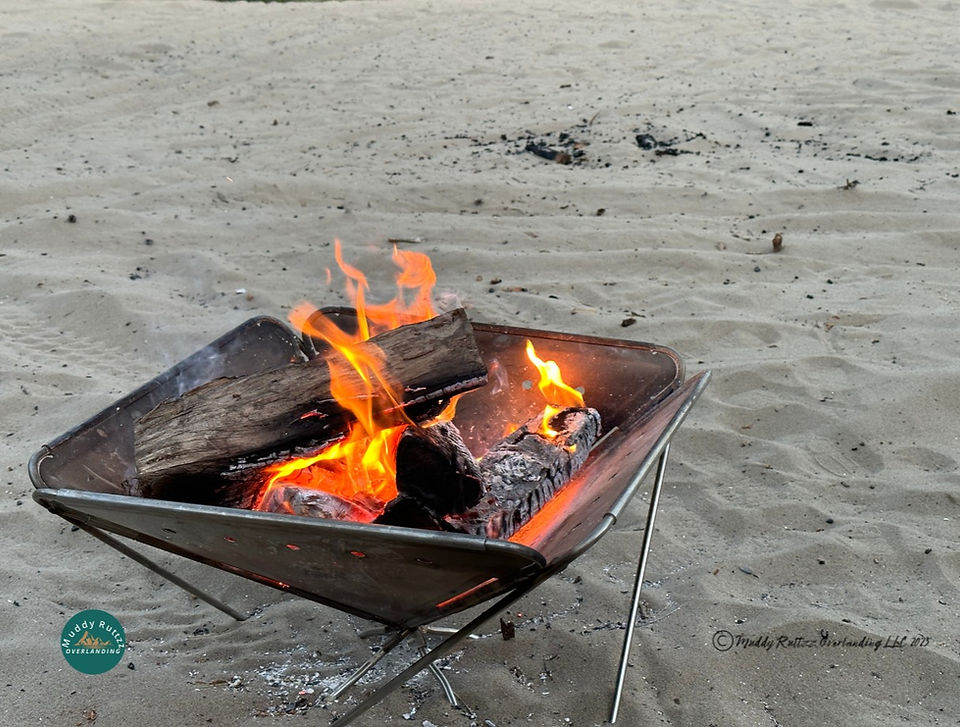 Campfires Not A Problem. Firepit with a roaring campfire sitting in the sand.