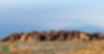 Rock formations in a desert setting under a clear sky. An RV is parked nearby. Text: "Campsites carved into history..." Mood is serene.
