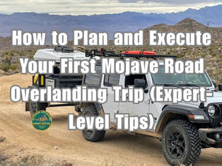 Trailer with roof top tent and white jeep parked on desert trail with hills and rocks in background. Text reads How to Plan and Execute your first Mojave Road Overlanding Trip (Expert-Level Tips)