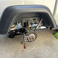 Coil spring is removed from Gladiator rear suspension and will be replaced with new from Jeep Bilstein lift kit.