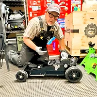 Muddy Ruttzz showing off floor jack purchased for DIY install of the Mopar Bilstein Lift Kit, Jeep parts crate and red lockers visible.