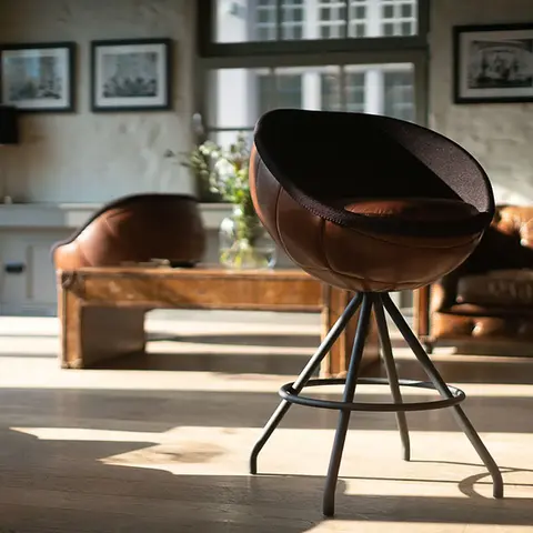 A retro soccer-themed Counter stool stands in the foreground, seen from the side in the living area, manufacturer lillus