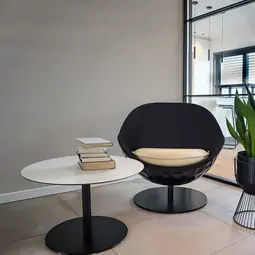 The waiting area features an eagle lounge chair made of black ABS plastic with original dimples, along with a lillus table with books.