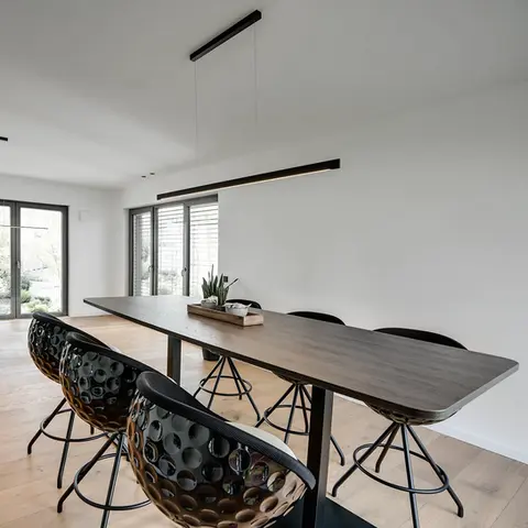 A bright room with Eagle bar stools in a golf ball design and a brown conference table in the meeting room, manufacturer Lillus