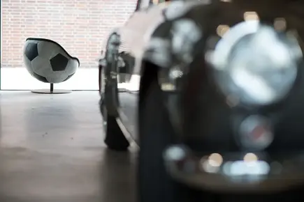 A classic car stands to the side at the front, matching the vintage leather, with a vintage soccer-themed lounge chair in the background. Manufacturer: lillus