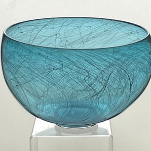 A blue glass bowl with swirls if black cane lines