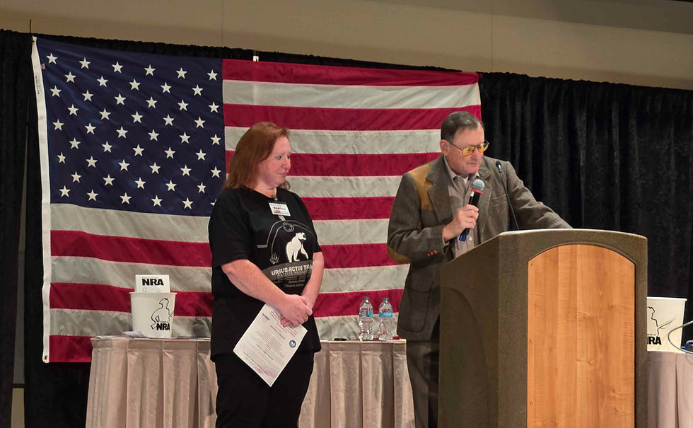 The club's president (left) accepting the grant from the NRA for firearms education.