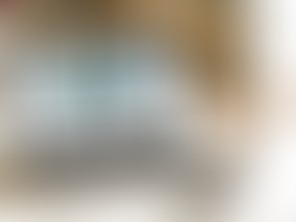 Um laptop sobre um sofá com imagem do site na tela