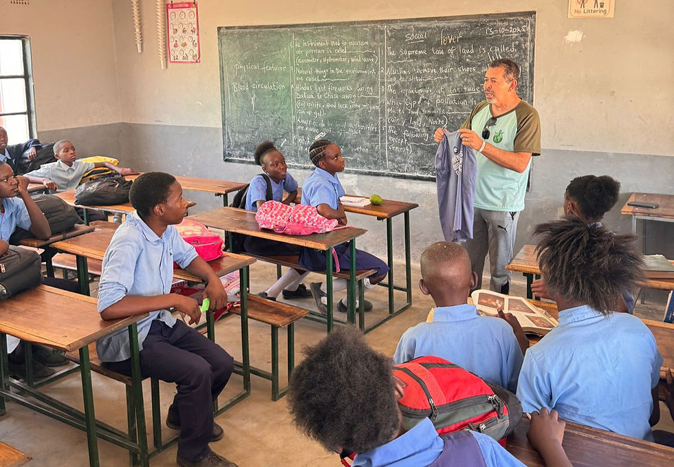 Companheiro do Rotary entregando doação de uniformes a alunos na África