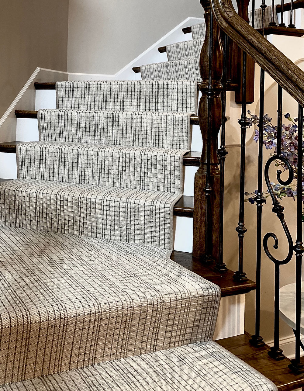 Carpeted staircase with dark wood banister