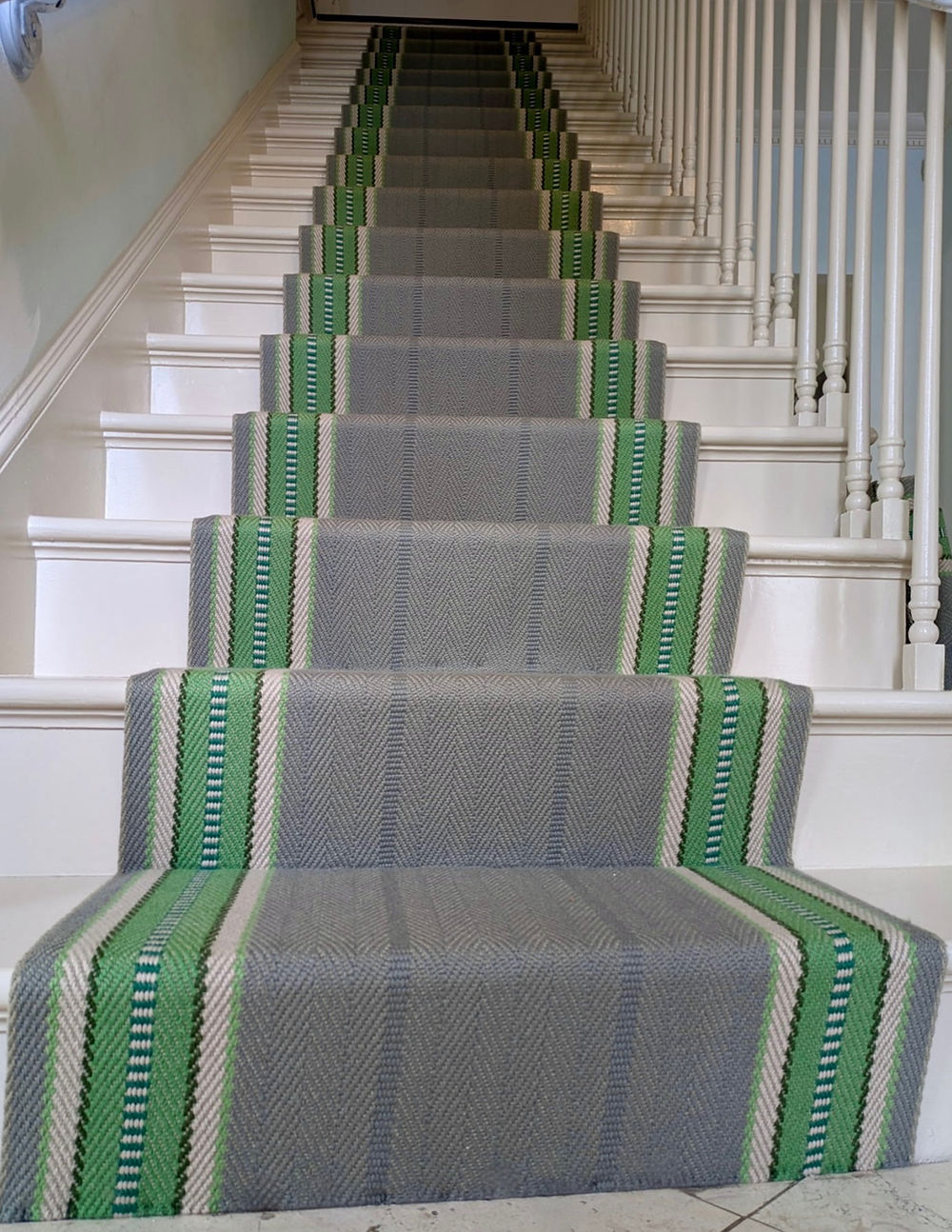 White staircase with gray and green runner