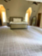 Bedroom with large bed and plaid carpet