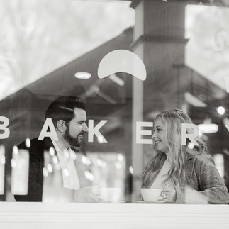 Couple drinking coffee through the bakery window