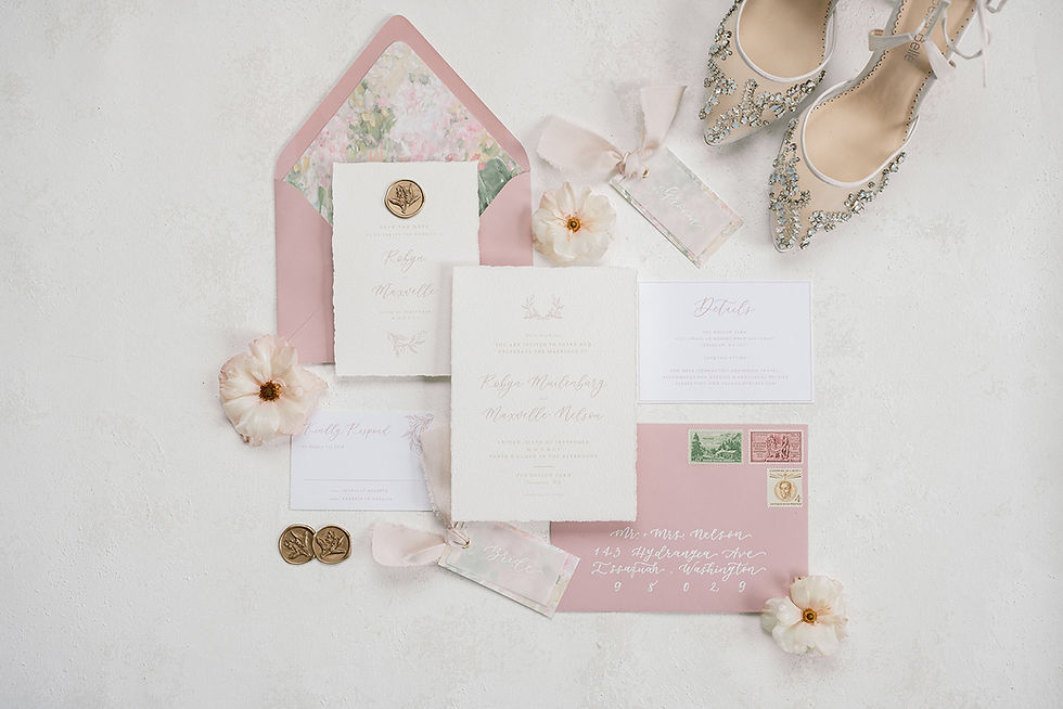 pink, white, and hints of green wedding stationary and the bride's shoes