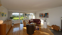 Das Wohnzimmer mit dem Ausgang auf den halb gedeckten Sitzplatz