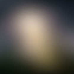 Una escena esperanzadora de brillante luz solar abriéndose paso entre oscuras nubes de tormenta sobre un apacible y antiguo cementerio cubierto de hiedra, simbolizando la esperanza cristiana de la resurrección y la vida eterna.