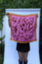 Woman holding Soy Infinita 100% silk scarf outdoors – bold pink botanical illustration with golden affirmation border by Ale
