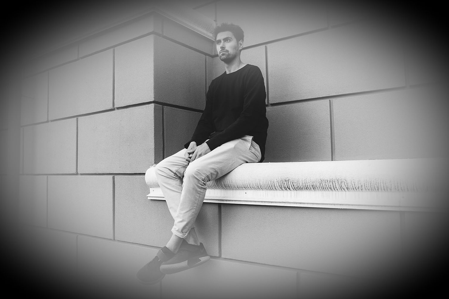 man sitting on a wall looking sad