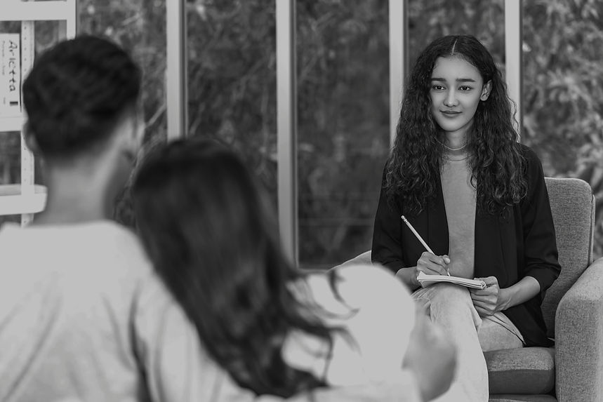 Couple engaged in a therapy session, working with a professional to improve communication and connection.