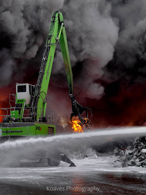 crane moving scrapyard fire piles to assist with extinguishment