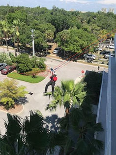 rope training firefighter repelling off a building in mid-air
