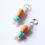 Thumbnail: Détail des perles en verre orange et bleu sur boucles d’oreilles Line faites main