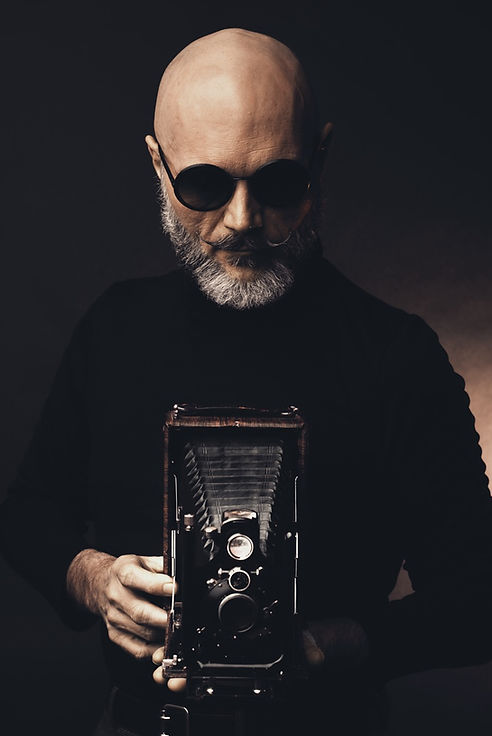 Portrait of a man holding a vintage camera