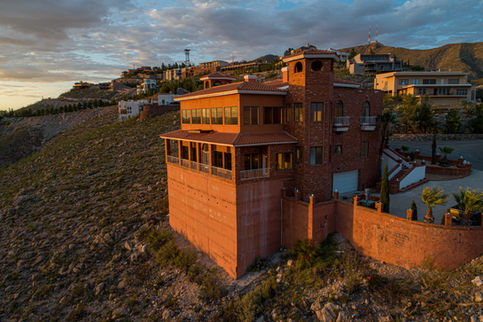 Grand hillside mansion at sunset