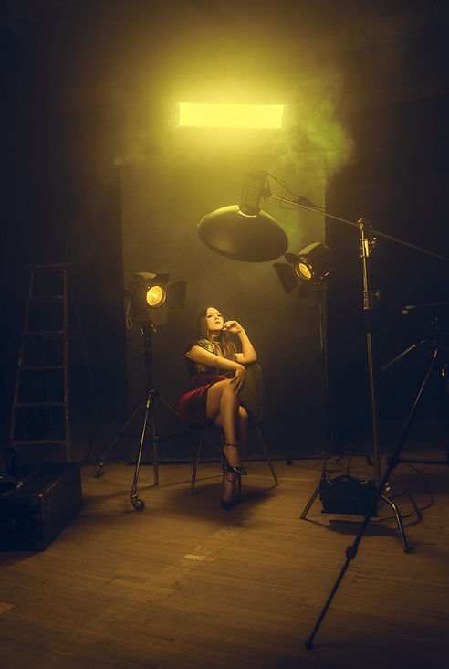 Woman sits in chair, night scene, dramatic lighting