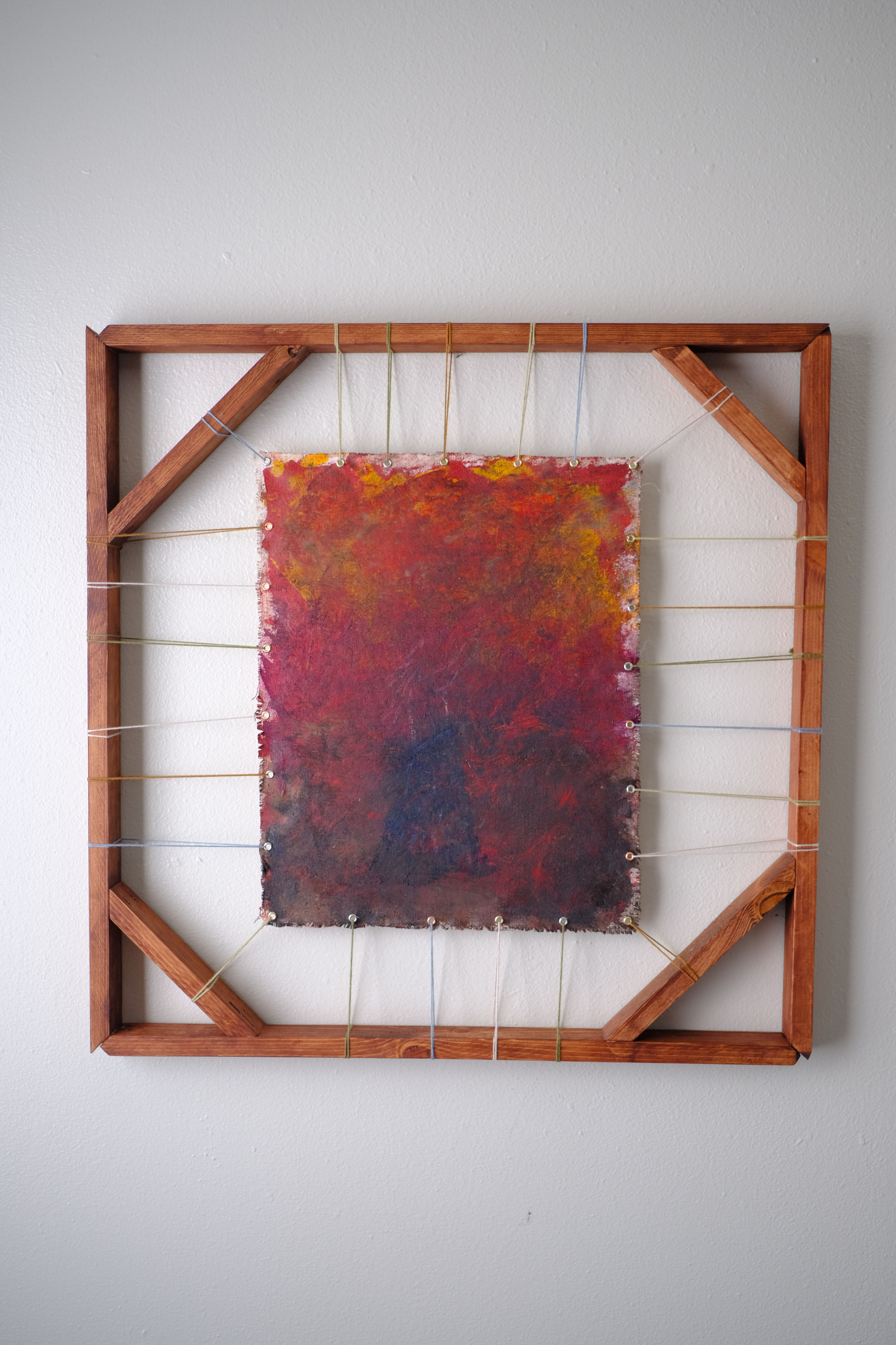 A painted canvas stretched between a dark wood frame