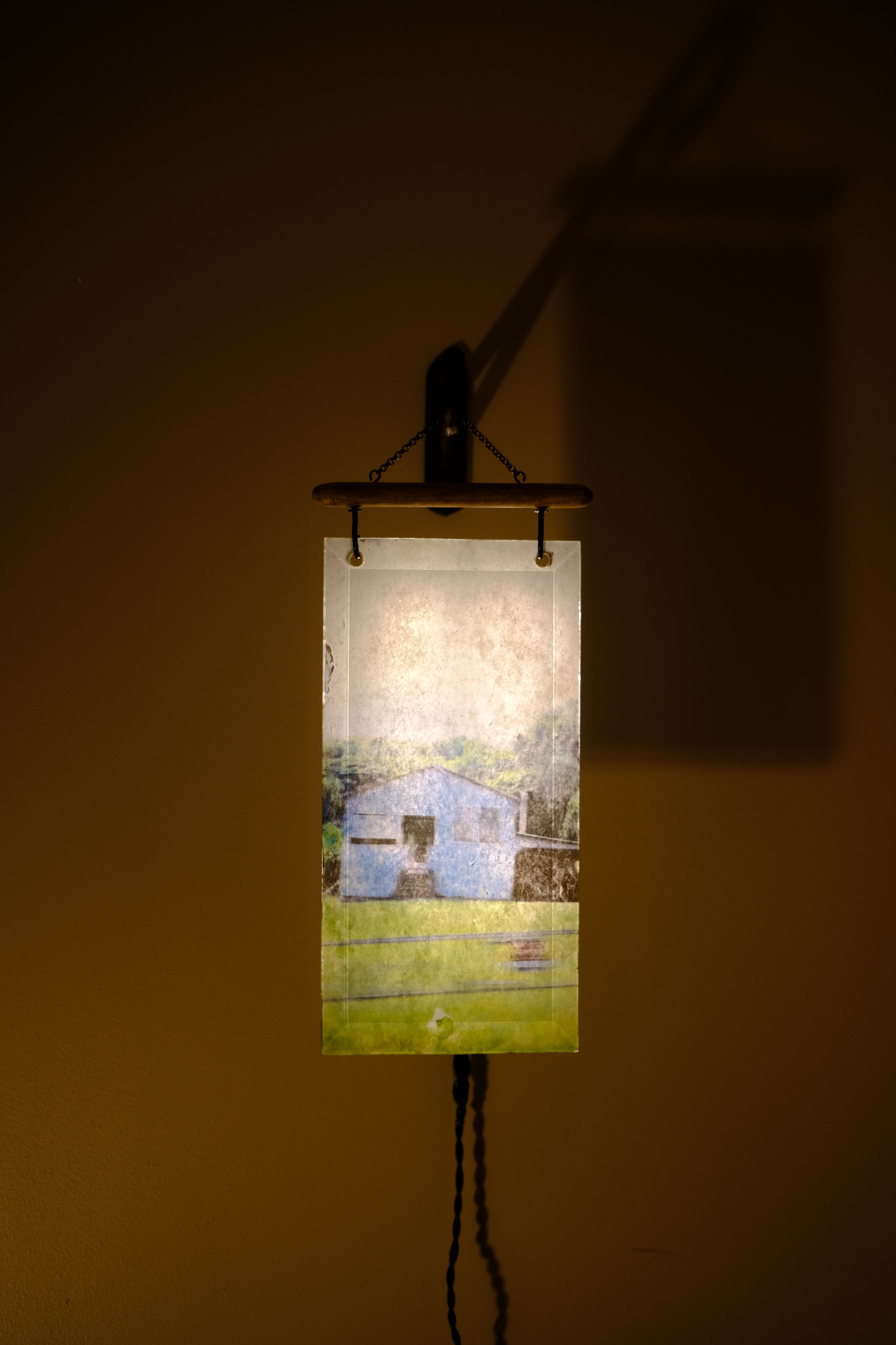 reverse-image transfer of a blue house in Hawaii on a glass pane