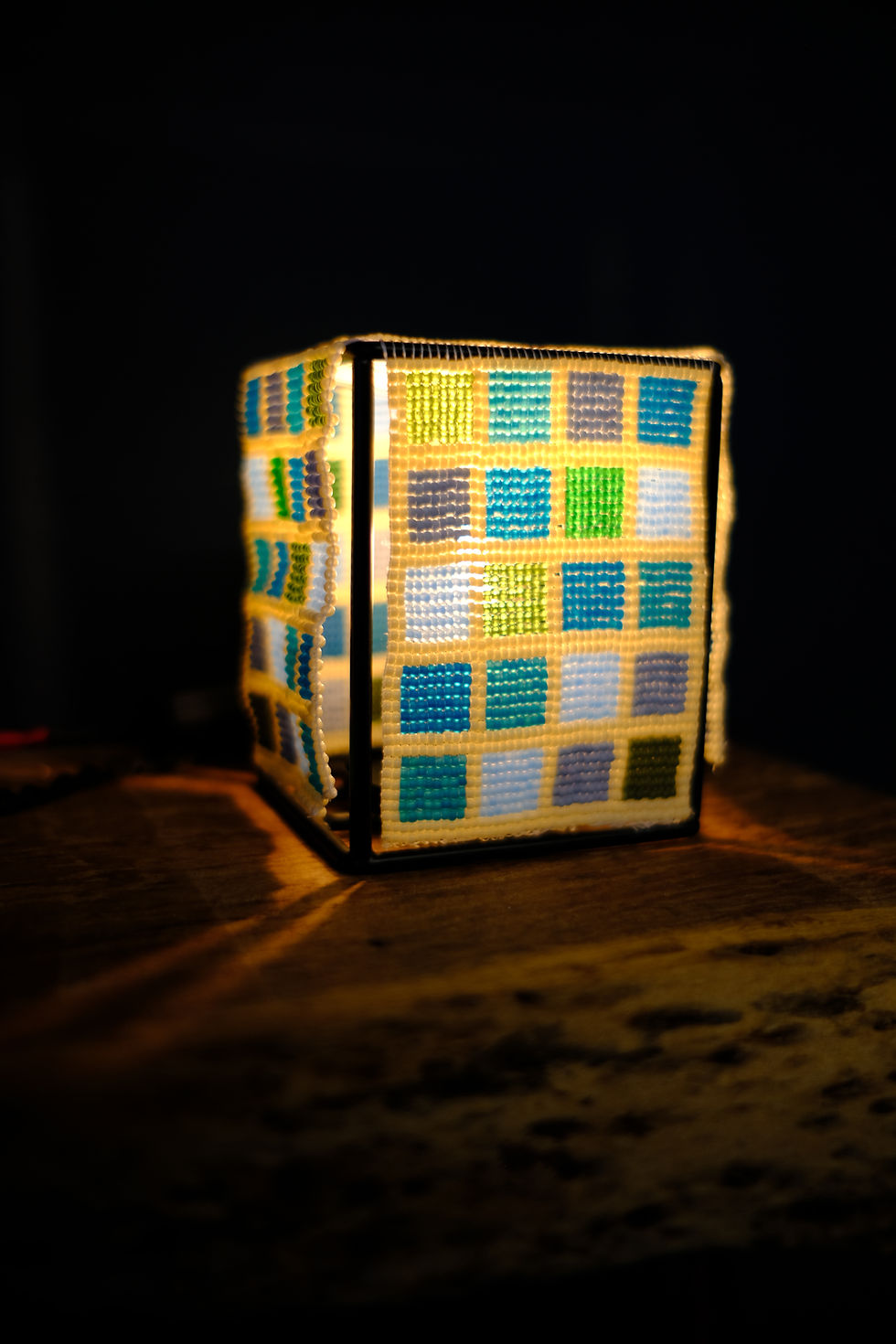 A small lamp with loom beaded checkered blues and greens 