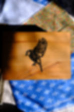 Wooden box with a black bird emblem