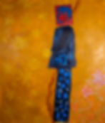 Large painting dominated by orange and yellow background. A figure in blue stands between stars and flowers.