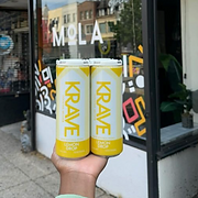 Sleek display of Krave Cocktails' canned seltzers on a modern countertop with vibrant backgrounds, showcasing the branding an