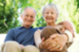 Stock image of an elderly white man and woman sitting together outside