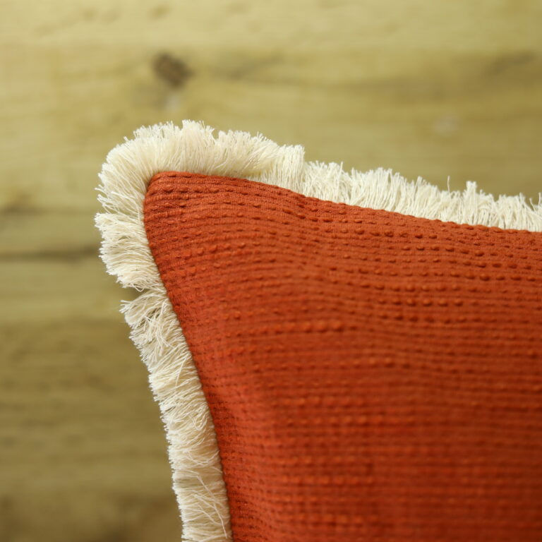Thumbnail: Ila 18x18 rust orange cushion cover with off-white hand-embroidered wildflowers and fringe by ZivaraJewels.