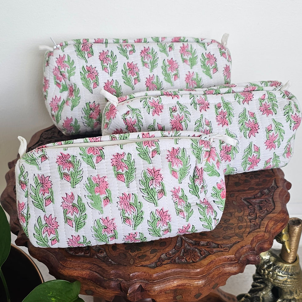 Three stacked hand-block printed petite wash bags with a pink floral and green leaf pattern on a white background.