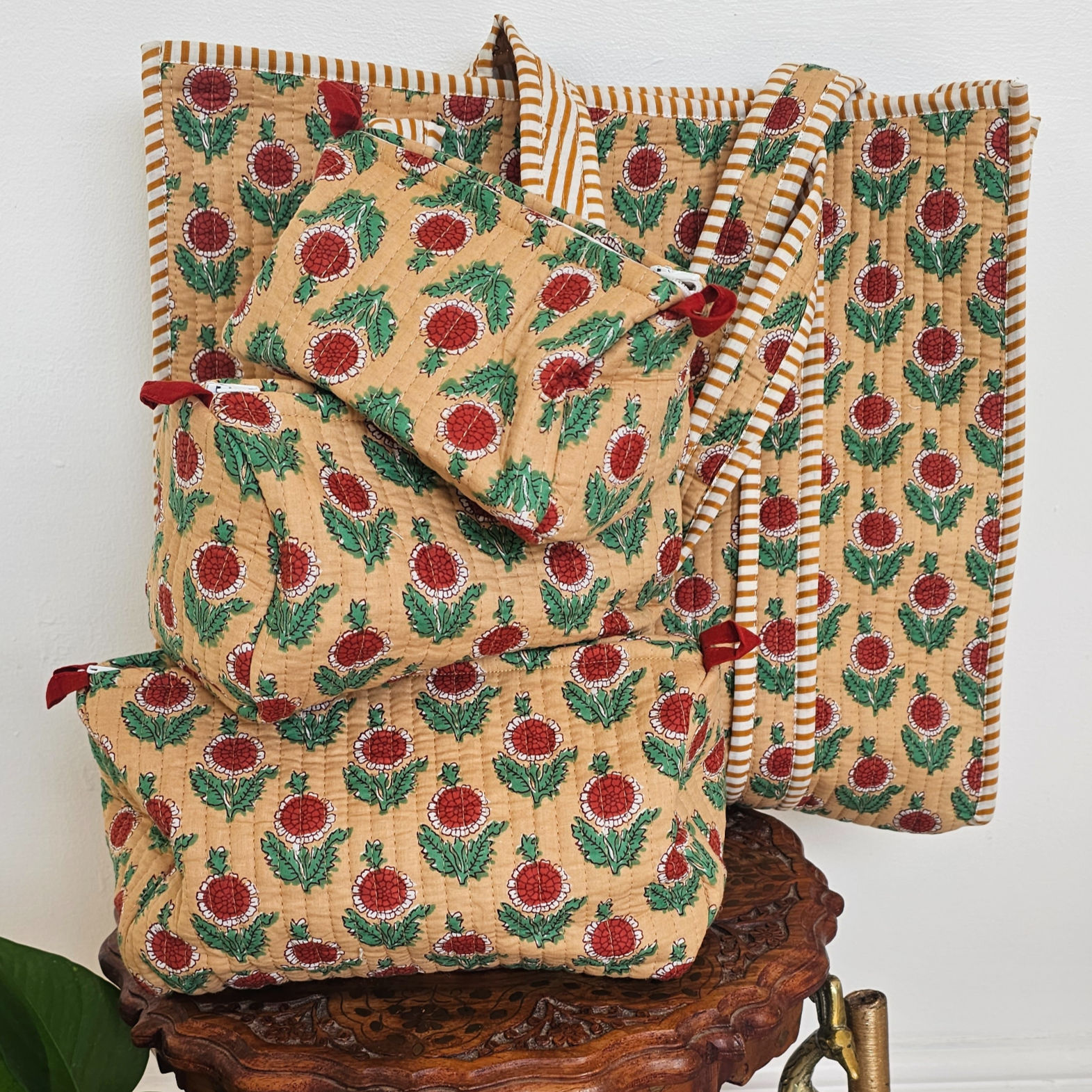 Coordinated Lavanya mustard and red hand-block travel set featuring a quilted tote bag and three matching wash bags.
