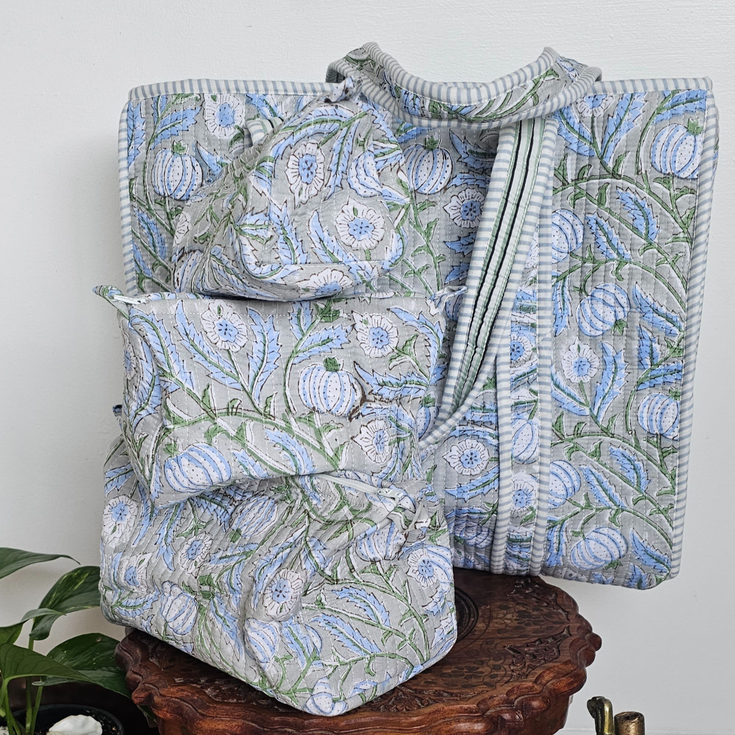 Coordinated Nīla blue hand-block printed travel set featuring a large quilted tote bag and three matching wash bags.