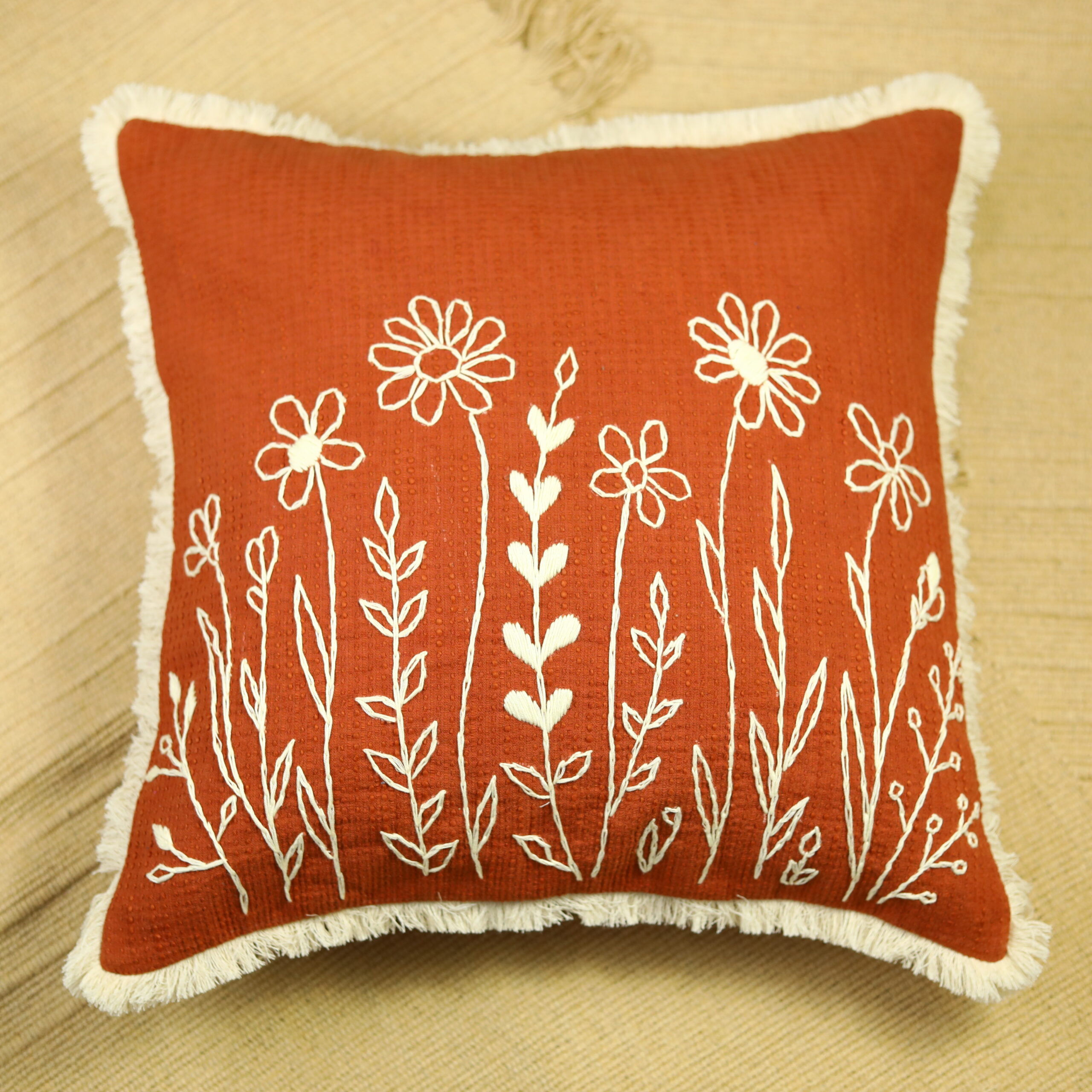 Ila 18x18 rust orange cushion cover with off-white hand-embroidered wildflowers and fringe by ZivaraJewels.