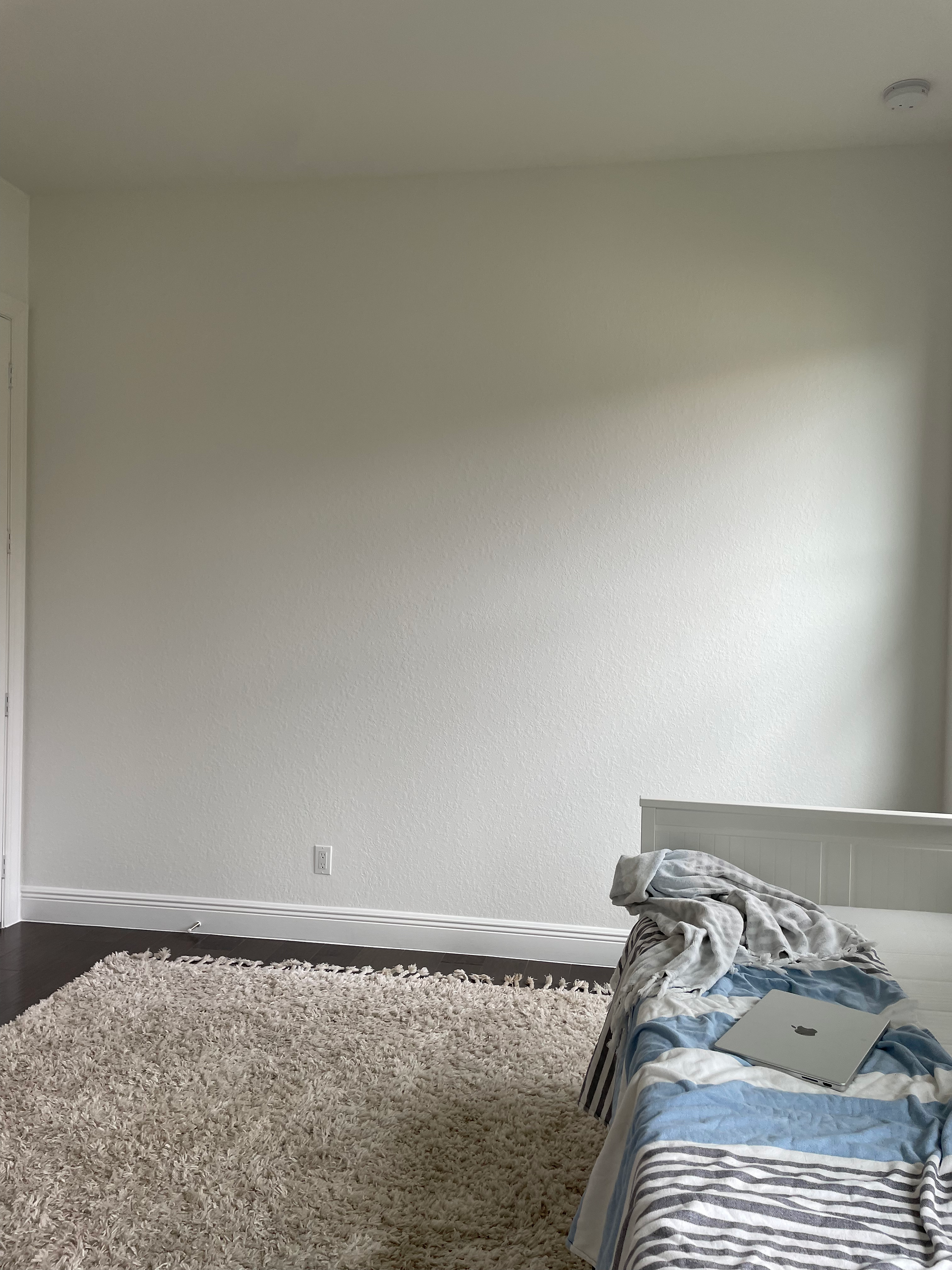 The beofre image of a nursery with blank white walls.