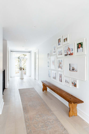 Light and airy hallway with a vintage rug in a Coral Gables home designed by Miami interior designer The Habitat Collective