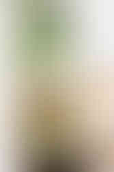 A cane chair and black side table with a modern black reading light