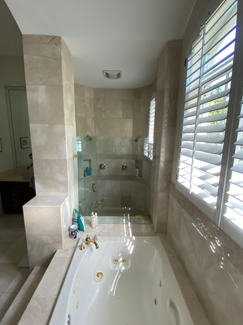 A dated bathroom with travertine walls and floors