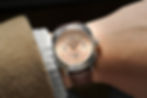 A doctor's watch with salmon colored dial by filipino microbrand called Makina Watches is seen here worn on the wrist.