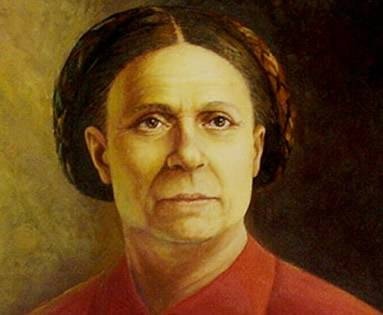 Retrato de Bárbara de Alencar apresentando uma mulher já na casa dos 50 anos com o cabelo escuro preso e camisa vermelha de gola alta